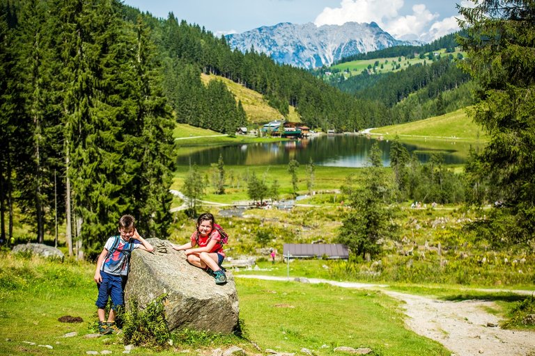 Kinder auf einem Stein vor dem Steirischen Bodensee | © TVB Haus-Aich-Gössenberg@René Eduard Perhab