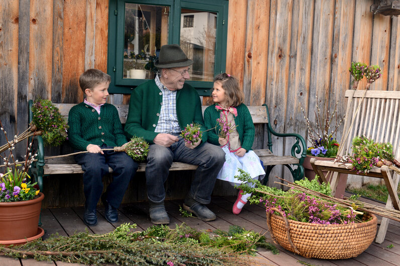Großvater und Enkelkinder beim Palmbuschenbinden | © Steiermark Tourismus / Atelier Jungwirth / Erich Hagspiel 