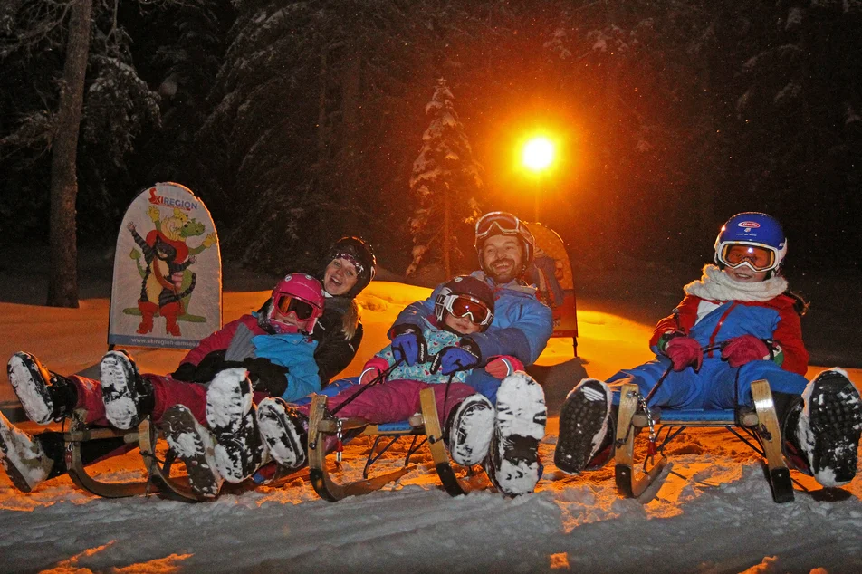 Familie auf Schlitten.  | © Hans-Peter Steiner