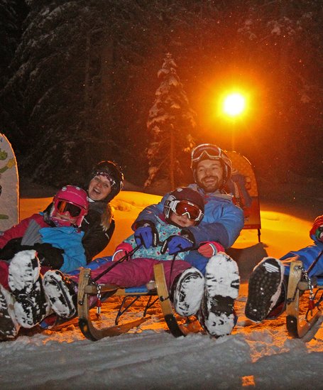 Familie auf Schlitten.  | © Hans-Peter Steiner